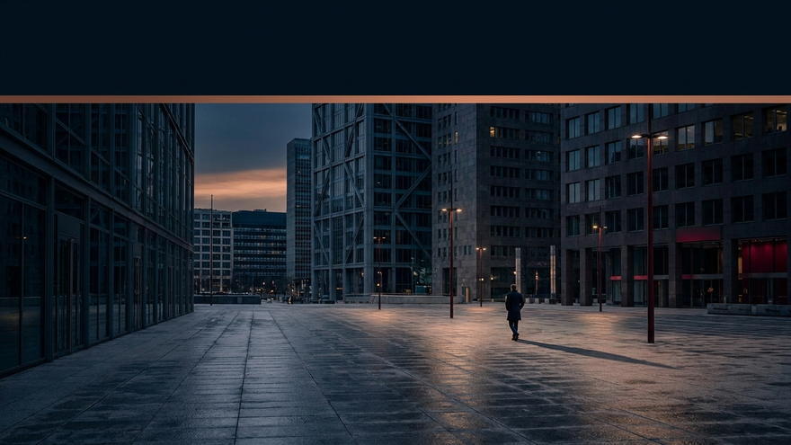 An empty avenue at dusk between two office towers